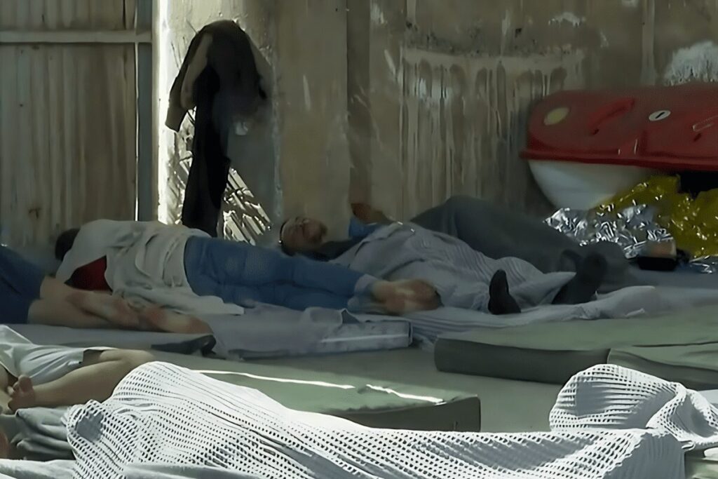 Les Migrants Rescapés Du Naufrage D’un Bateau De Migrants En Grèce, Dormant Dans Un Hangar Après Leur Sauvetage
