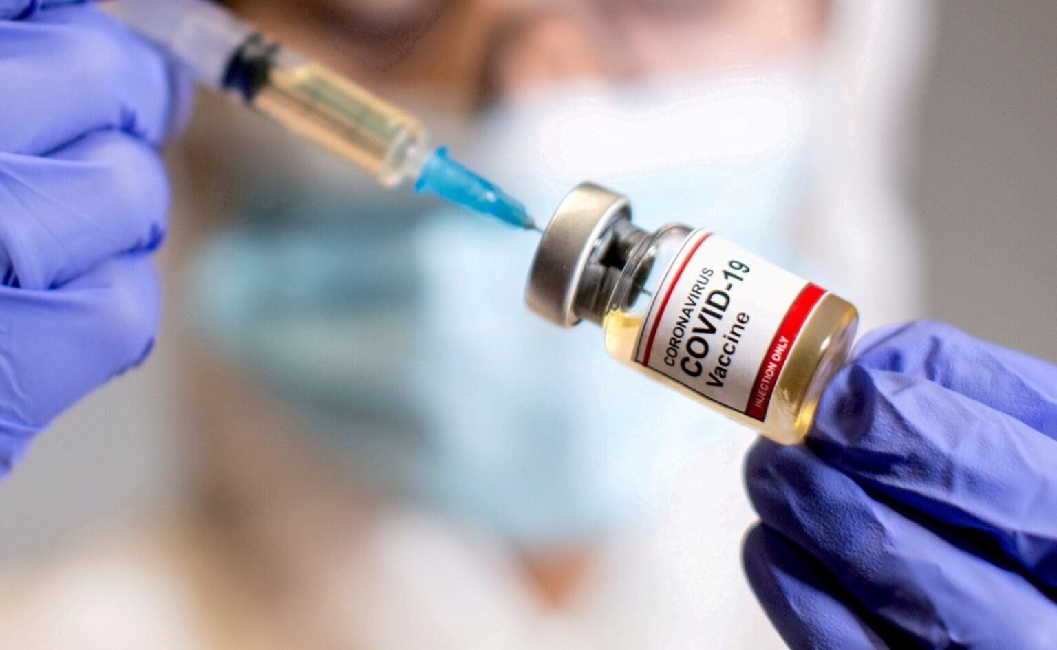 FILE PHOTO: FILE PHOTO: A woman holds a medical syringe and a small bottle labelled « Coronavirus COVID-19 Vaccine