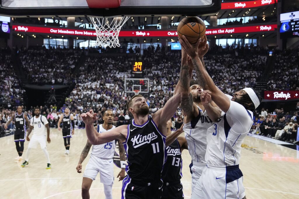 Sacramento Kings center Domantas Sabonis (11) and Dallas Mavericks forward Anthony Davis (3) compete for a rebound during the first half of an NBA play-in tournament basketball game Wednesday, April 16, 2025, in Sacramento, Calif.