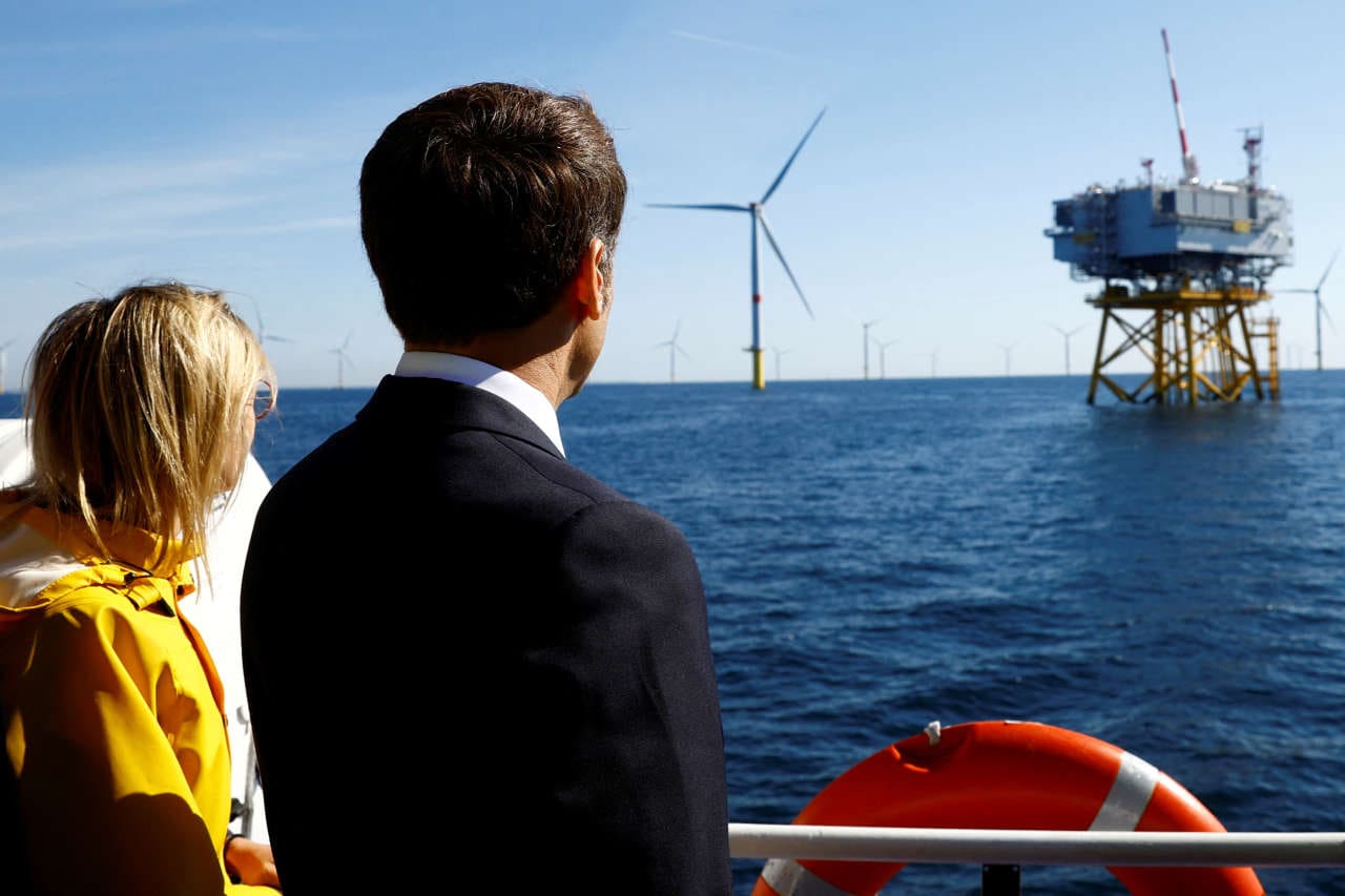 French President Emmanuel Macron On Board A Boat With French Minister For Energy Transition Agnes Pannier-Runacher Looks At Wind Turbines During A Visit At The Saint-Nazaire Offshore Wind Farm, Off The Coast Of The Guerande Peninsula In Western France, September 22, 2022. Reuters/Stephane Mahe/Pool