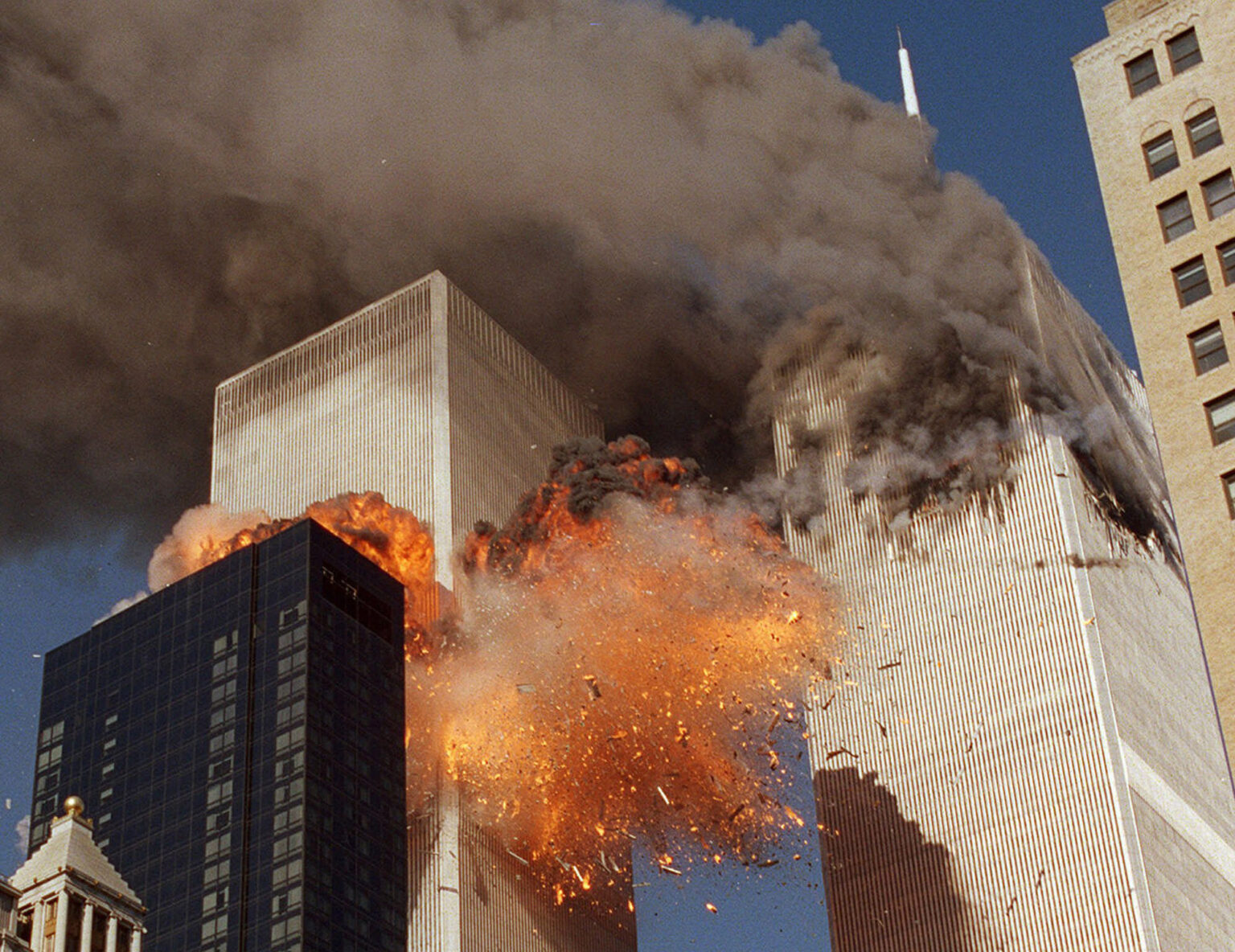 FILE- In this Sept. 11, 2001 file photo, smoke billows from World Trade Center Tower 1 and flames explode from Tower 2 as it is struck by American Airlines Flight 175, in New York. For New Yorkers in or near the World Trade Center on Sept. 11, 2001, the sights and sounds of everyday life can still trigger painful memories and strong psychological reactions to the attacks. (AP Photo/Chao Soi Cheong, File) MANDATORY CREDIT AP Photo/Chao Soi Cheong, File