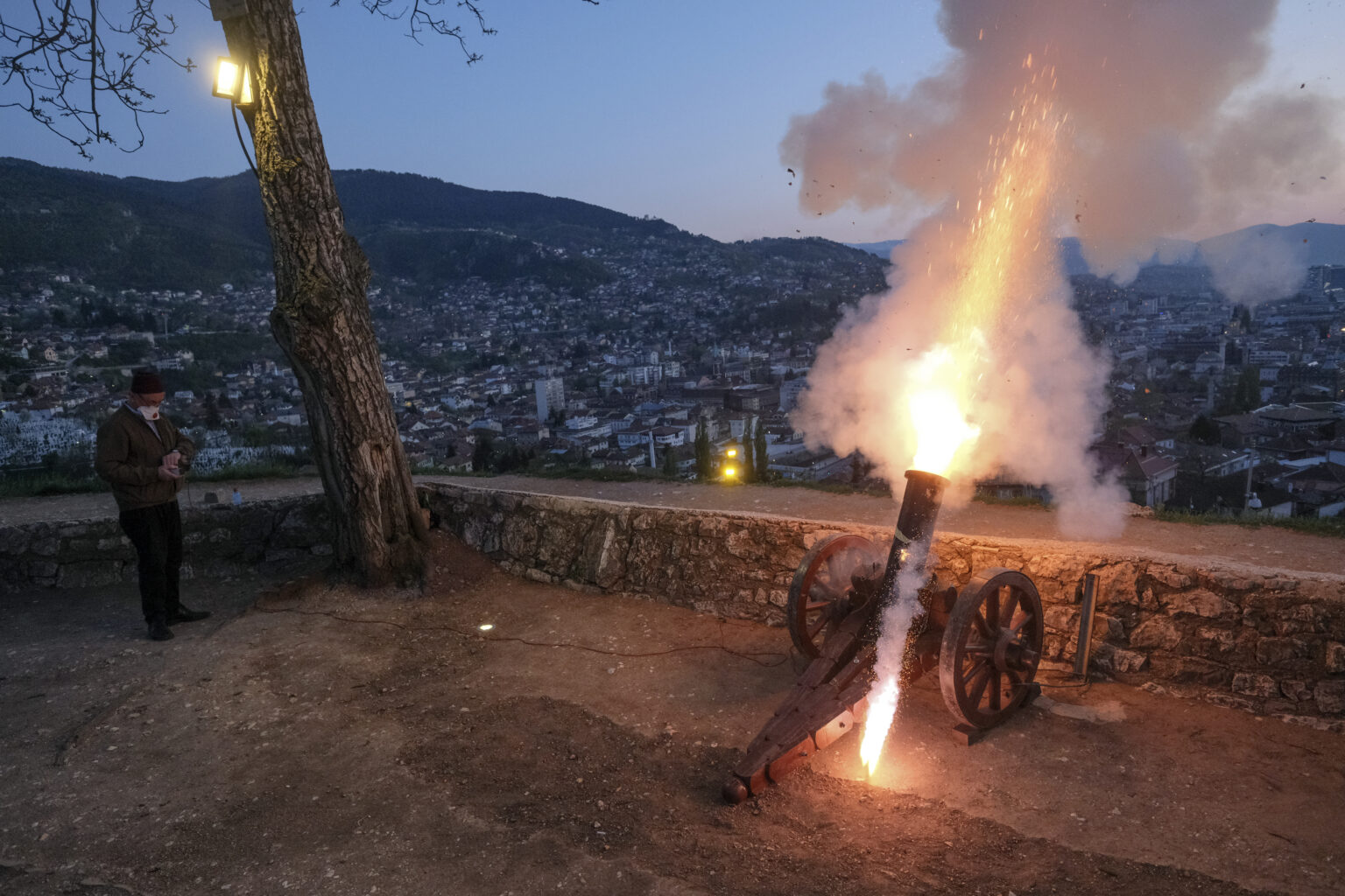 Un homme tire avec un canon ancien pour signaler la rupture du jeûne peu après le coucher du soleil à Sarajevo, en Bosnie, lors du premier jour du mois sacré de jeûne du Ramadan. (AP/Kemal Softic)