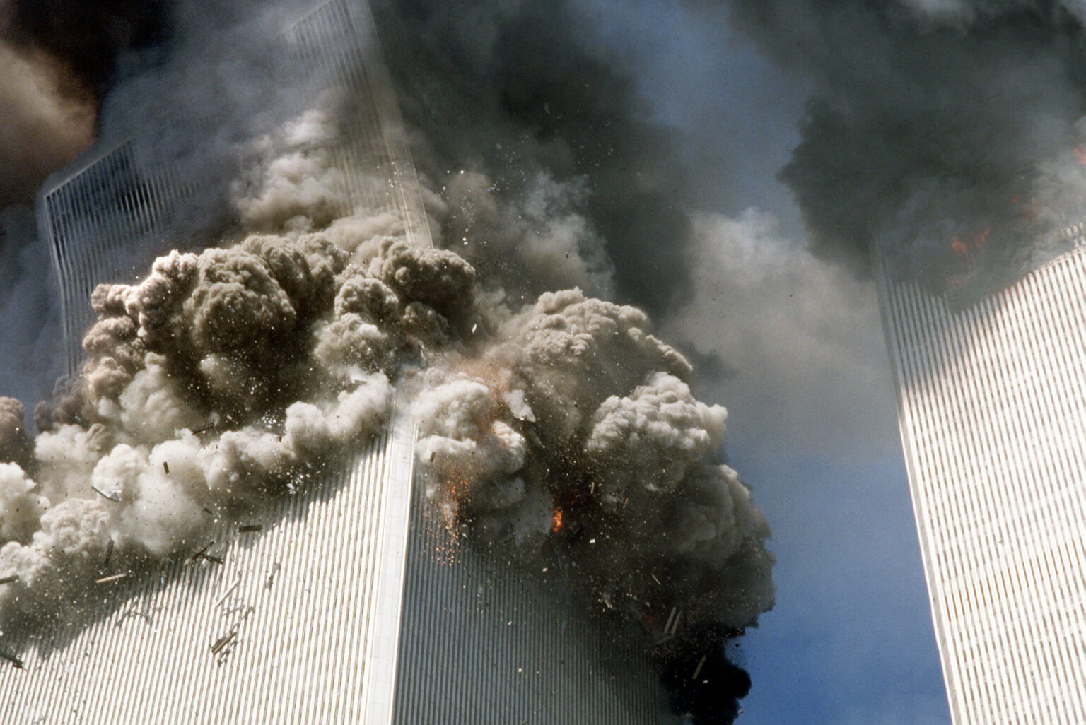 FILE - In this Sept. 11, 2001, file photo, the south tower of the World Trade Center, left, begins to collapse after a terrorist attack on the landmark buildings in New York. Families impacted by the terrorist attacks say it's important for the nation to pause and remember the hijacked-plane attacks that killed nearly 3,000 people at the World Trade Center, at the Pentagon and near Shanksville, Pa., on Sept. 11, 2001, shaping American policy, perceptions of safety and daily life in places from airports to office buildings. (AP Photo/Gulnara Samoilova, File) AP Photo/Gulnara Samoilova, File