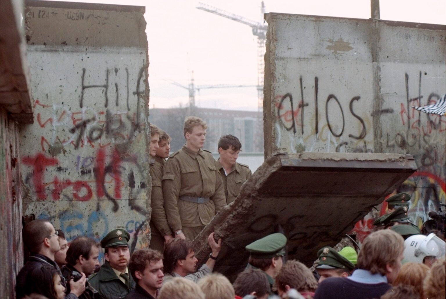 Novembre 1989. Des gardes-frontières est-allemands sont visibles à travers une ouverture dans le mur de Berlin, après que des manifestants ont fait tomber un segment du mur près de la porte de Brandebourg, à Berlin. Lors de la chute du mur de Berlin, l’Union soviétique s’est retirée, laissant le gouvernement communiste de l’Allemagne de l’Est s’effondrer, avant d’accepter rapidement la réunification allemande. (AP/Lionel Cironneau)