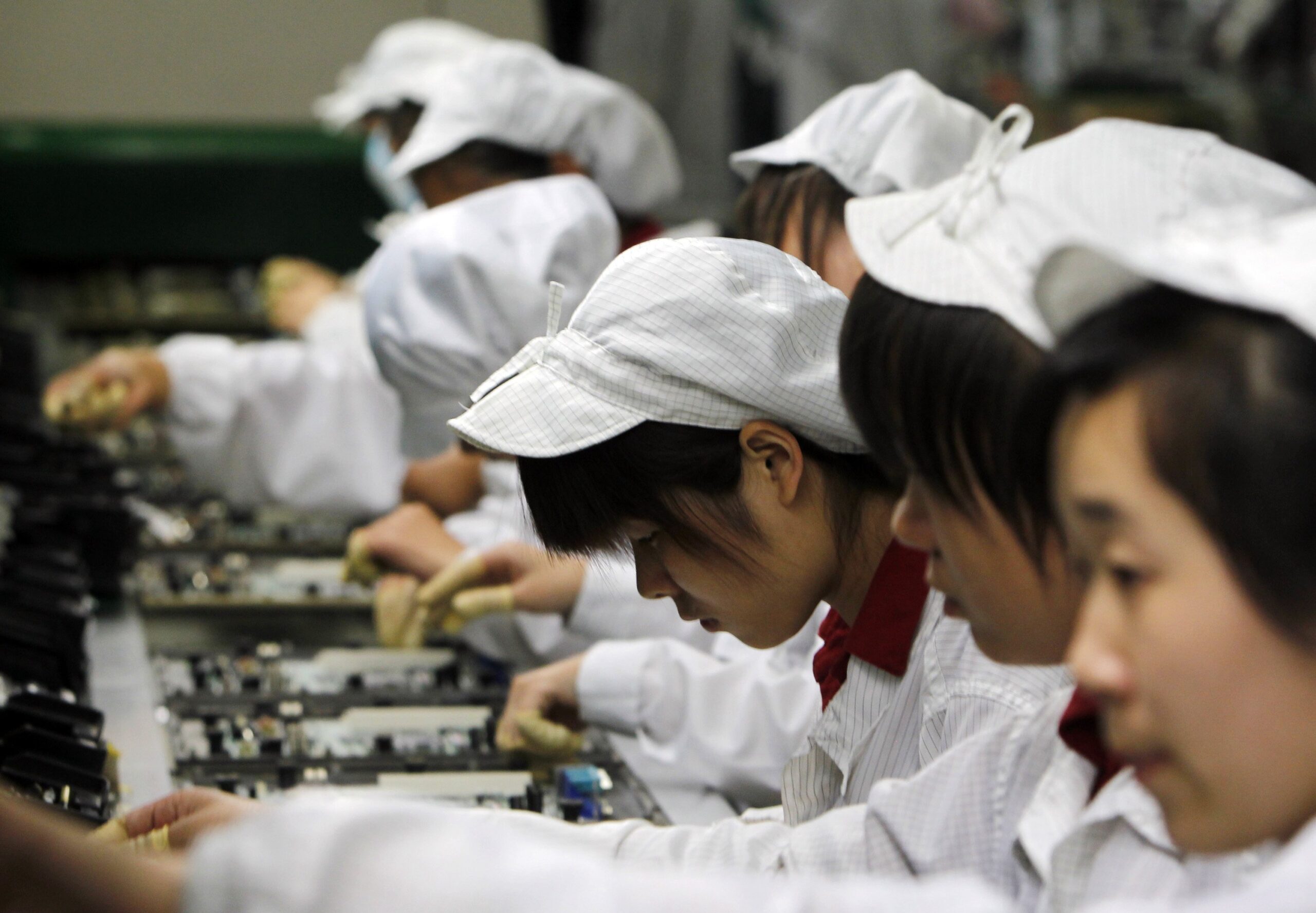 Staff Members Work On The Production Line At The Foxconn Complex In The Southern Chinese City Of Shenzhen, Southern City In China, Wednesday, May 26, 2010. The Head Of The Giant Electronics Company Whose Main Facility In China Has Been Battered By A String Of Worker Suicides Opened The Plant'S Gates To Scores Of Reporters Wednesday, Hours After Saying That Intense Media Attention Could Make The Situation Worse. (Ap Photo/Kin Cheung) Ap Photo/Kin Cheung