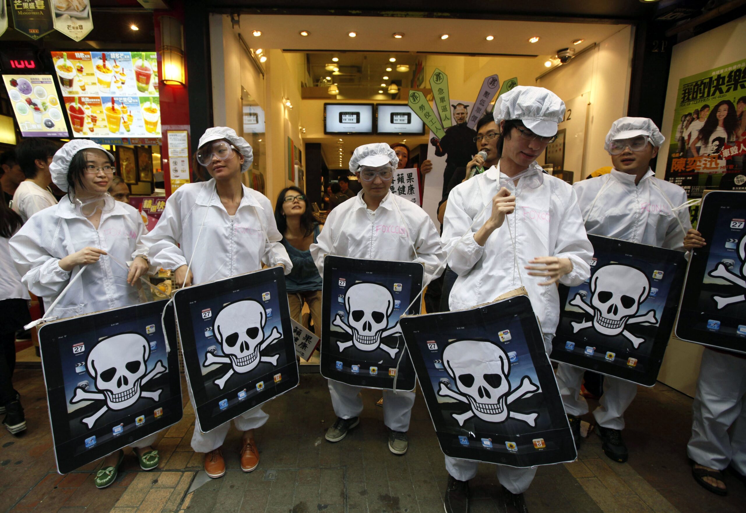 File - In This Saturday, May 7, 2011 File Photo, Local And Mainland Chinese Universities' Students, Dressed As The Foxconn Workers, Hold Mock Ipads With A Skeleton Print Outside An Apple Premium Reseller Shop In Hong Kong. Foxconn, The Company That Makes AppleS Iphones Suspended Production At A Factory In China On Monday, Sept. 24, 2012, After A Brawl By As Many As 2,000 Employees At A Dormitory Injured 40 People. The Fight, The Cause Of Which Was Under Investigation, Erupted Sunday Night At A Privately Managed Dormitory Near A Foxconn Technology Group Factory In The Northern City Of Taiyuan, The Company And Chinese Police Said. (Ap Photo/Kin Cheung, File) Ap Photo/Kin Cheung, File